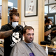 A barber wearing a face mask works on a customer’s hair at Board & Blade on May 14, 2020 in Auckland, New Zealand.